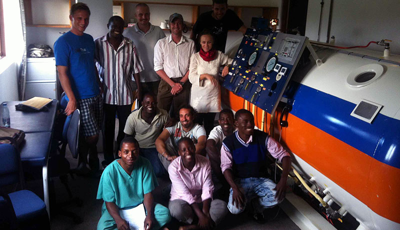 Group photo of students in front of hyperbaric chamber