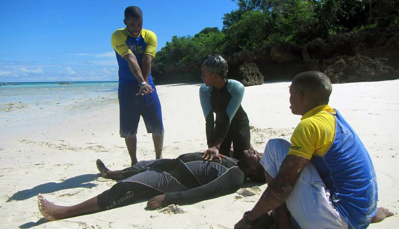Scuba Do Zanzibar instructor coaching Chumbe Island rangers on hand positioning for administrating CPR