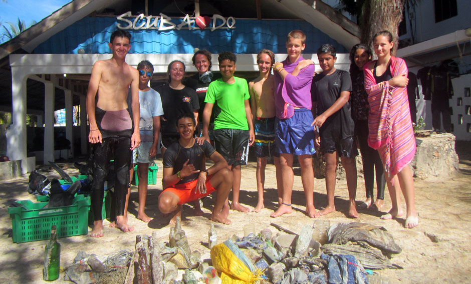 Students with instructor showing trash collected from the ocean on a cleanup dive