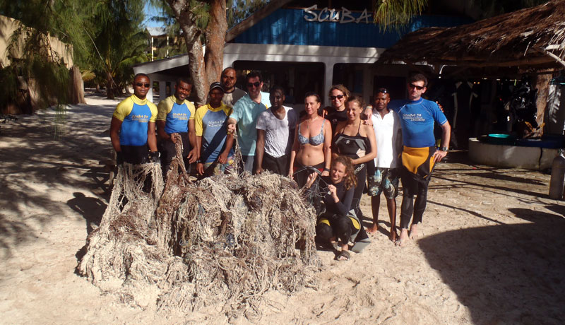 Team of divers in front of Scuba Do Zanzibar Kendwa dive base with net which was removed from the coral reef